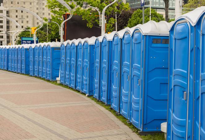 a row of portable restrooms at an outdoor special event, ready for use in Commerce